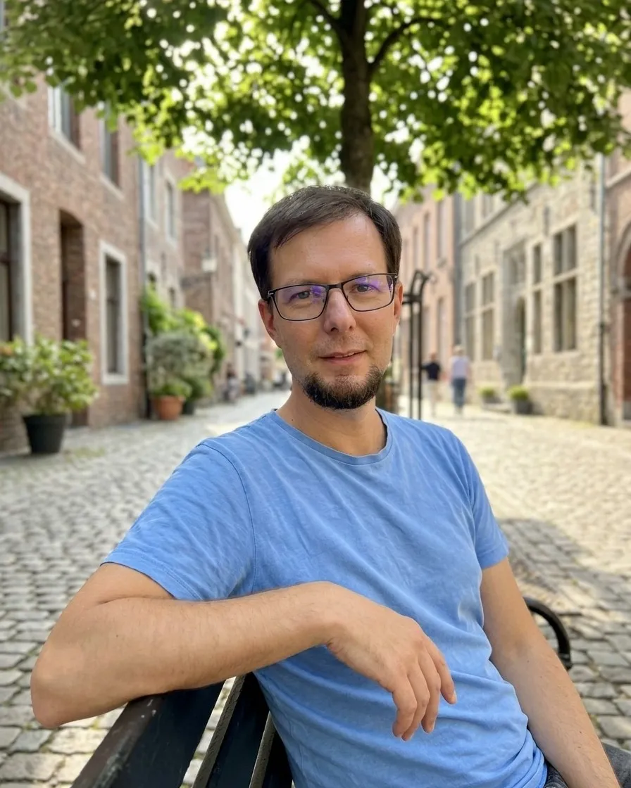 Roland Theisen, founder of Lëtz Develop, on a bench in a cobbled old town street